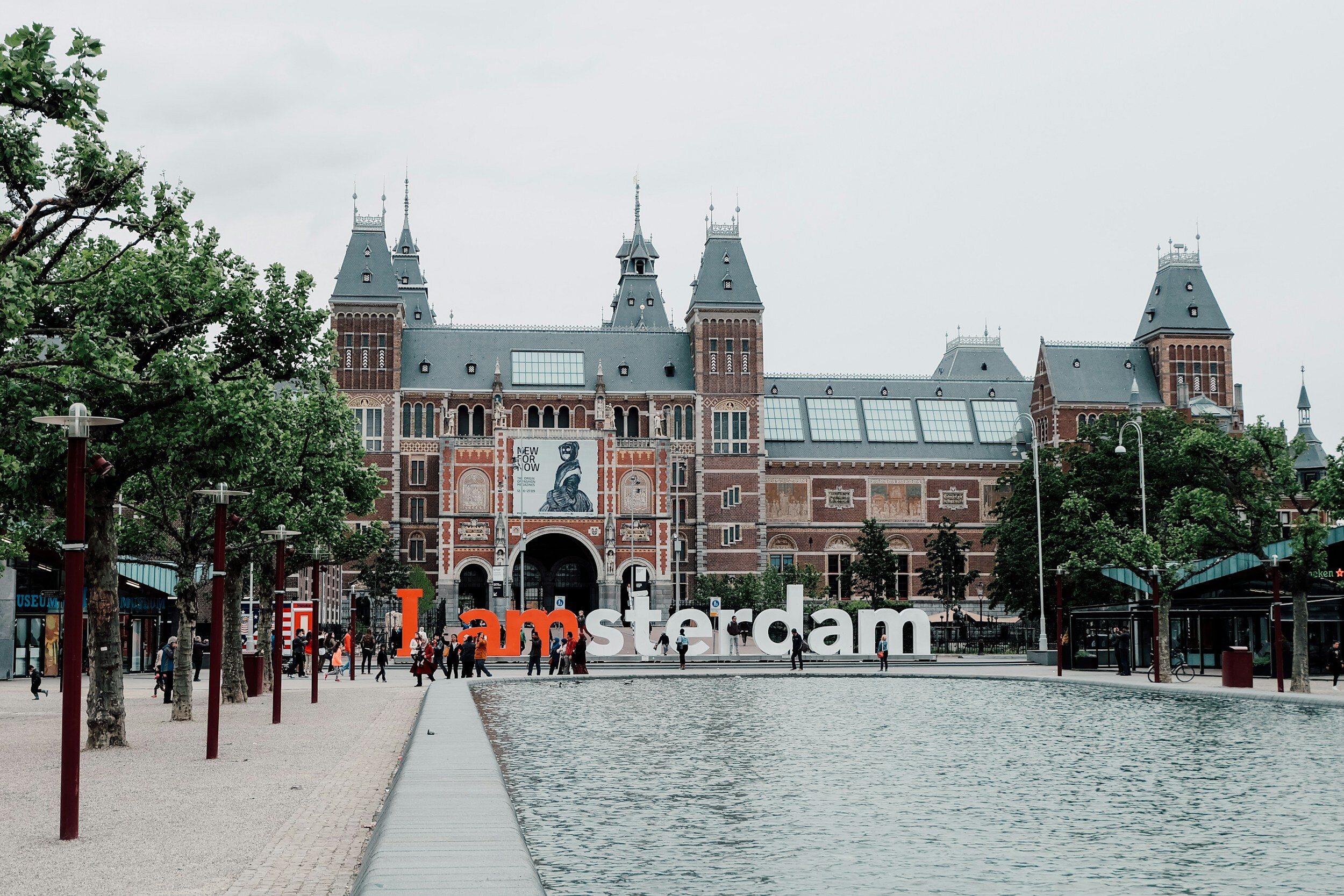 Red "I Am" White "sterdam" against the Rijksmuseum exterior and open courtyard