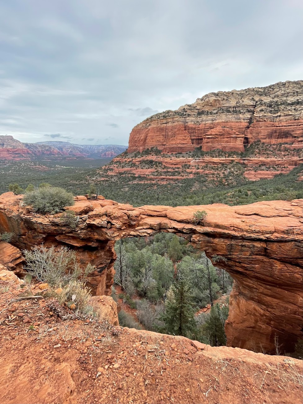 Red rock arch against natural green and red rock background