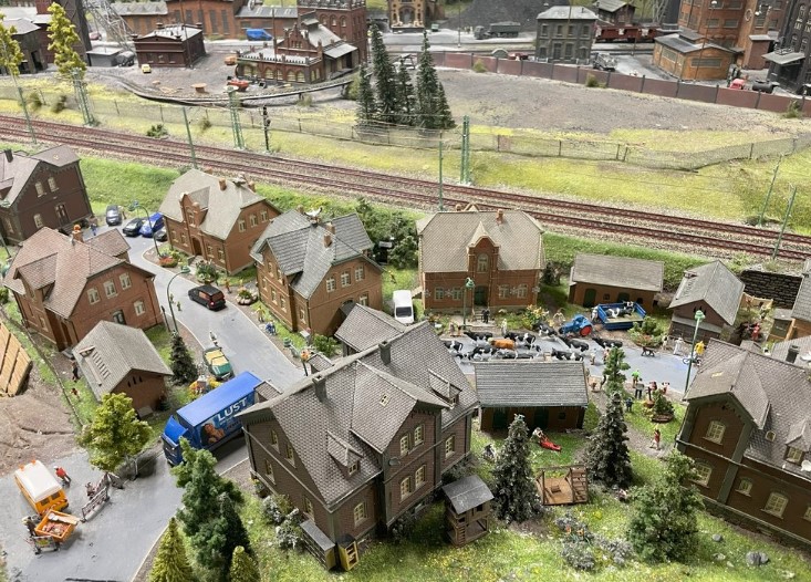 Miniature village from above, multiple rooftops over green space